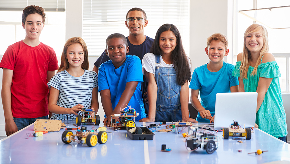 group of middle school students working on robots project