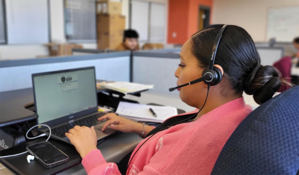 Staff with headset on working on a computer